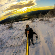 Adventurous skier capturing a dynamic selfie on a snowy mountain.