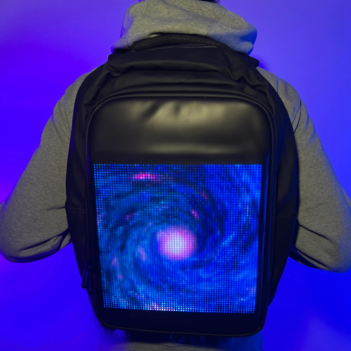 A person wearing a backpack with a customizable LED screen on the back, controlled via a smartphone app.