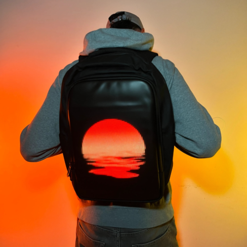 A person wearing a backpack with a customizable LED screen on the back, controlled via a smartphone app.