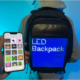 A person wearing a backpack with a customizable LED screen on the back, controlled via a smartphone app.